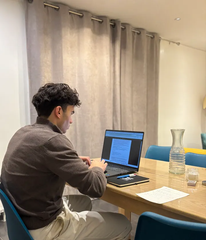A student working on a laptop at a table.
